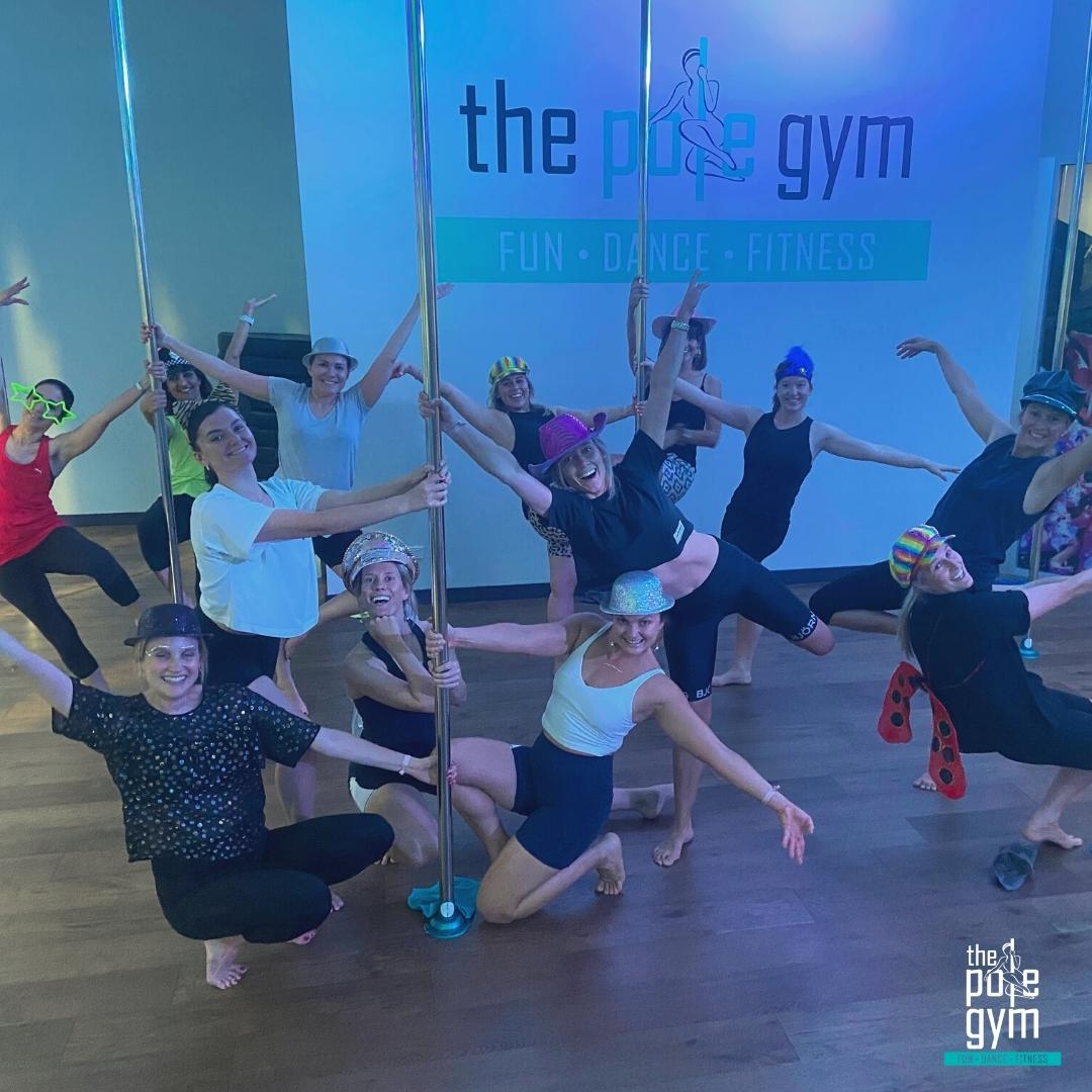 A group of women having fun and pole dancing in a Deluxe Pole Party at The Pole Gym Brisbane City.